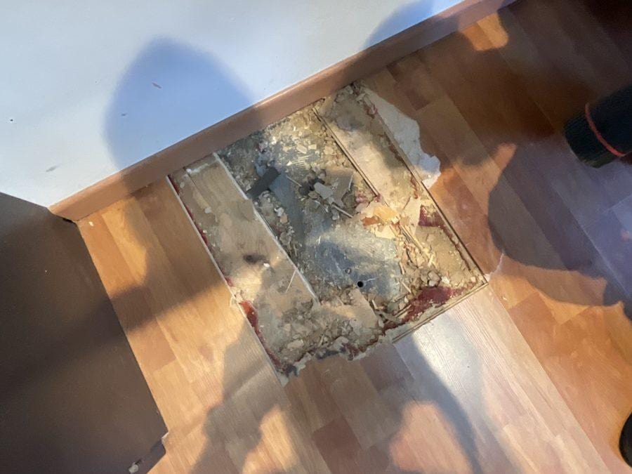 Sondage destructif localisé dans le plancher de la mezzanine, montrant le parquet, le remplissage et un élément métallique