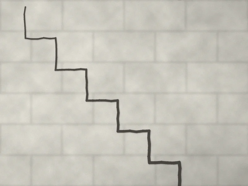 Fissure en escalier suivant les joints d'une maçonnerie de blocs
